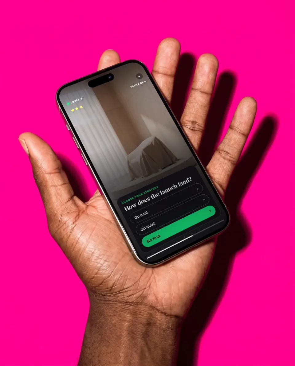 A phone on an open palm against a magenta backdrop, playing a product launch quest: how does the launch land?